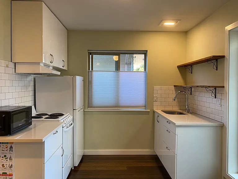 kitchenette has four burner electric, true range hood venting outside, sink and appliance.