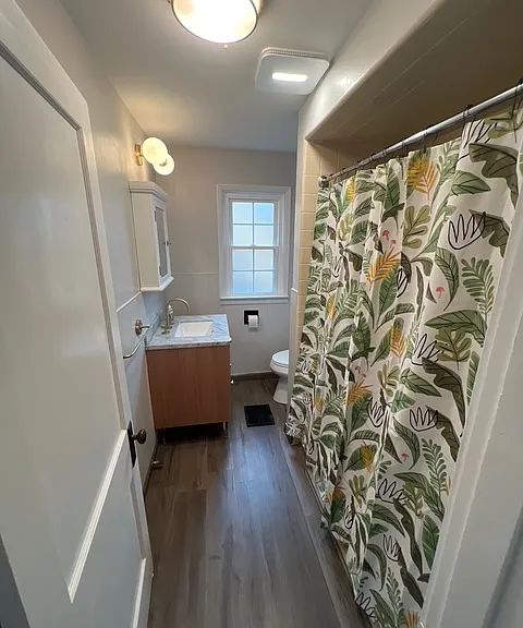2nd floor bathroom with a brand new vanity fixture, brand new lighting, brand new toilet & cabinetry.