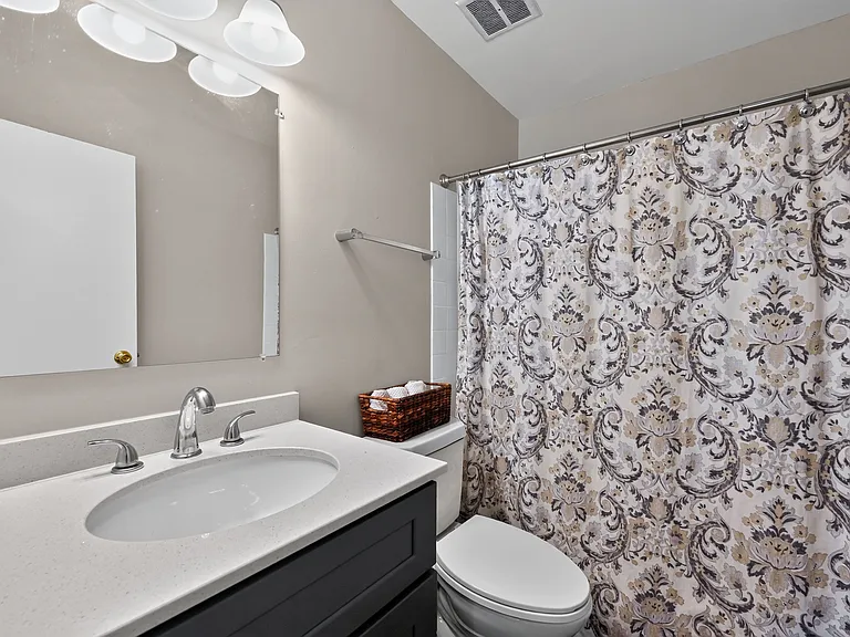 Enjoy a clean, modern bathroom featuring crisp white fixtures at Renaissance at Carol Stream in Carol Stream, IL.