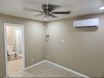 Part of room where it shows the enterance to the bathroom, Minisplit, and wiring for cable TV.