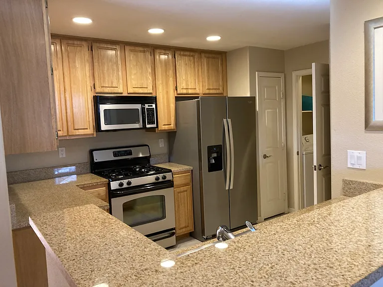 Kitchen with granite countertops and stainless appliances. Gas cooking range.
