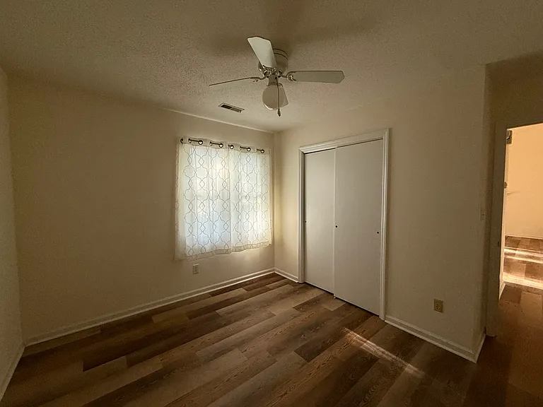 The second bedroom/office/studio has generous closet space with built-in shelves. Ceiling fan and two layers of window treatments are provided.