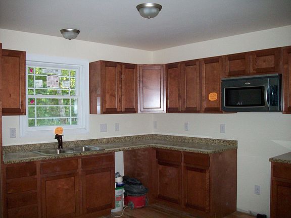 SOLID GALZED CABINETRY IN A FULL EAT IN KITCHEN AND GRANITE COUNTERTOPS
