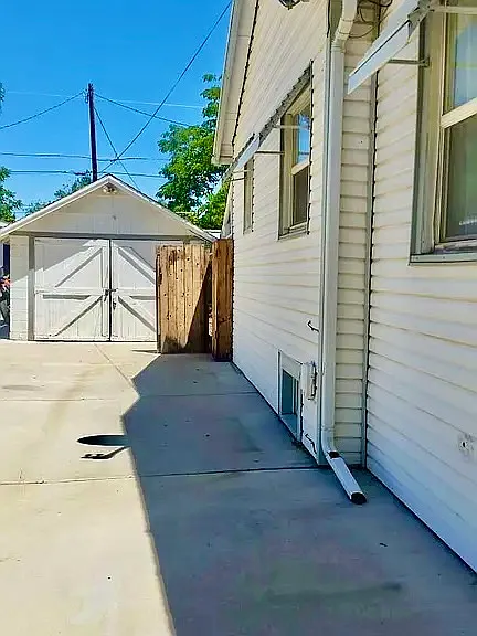 Picture of huge paved driveway, room for 3 cars, leading to one-car garage.
