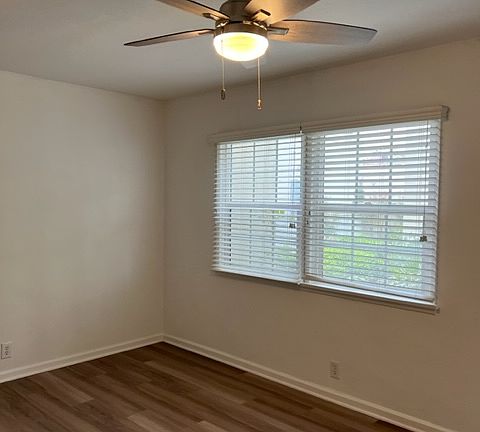 Living area with beautiful flooring and new windows.