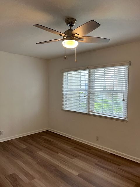 Living area with beautiful flooring and new windows.