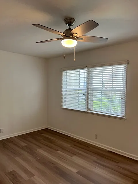Living area with beautiful flooring and new windows.