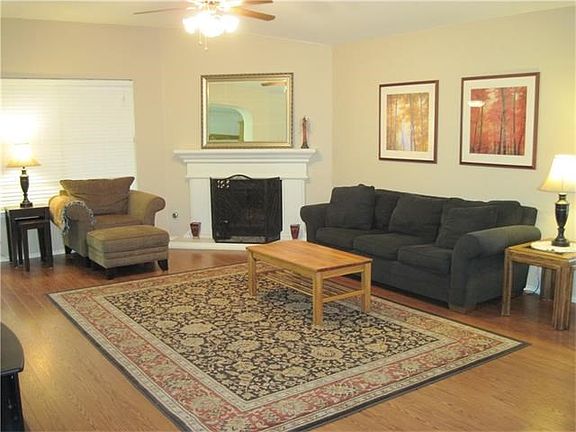Great Family Room with corner Fireplace, ceiling fan and laminate wood flooring.