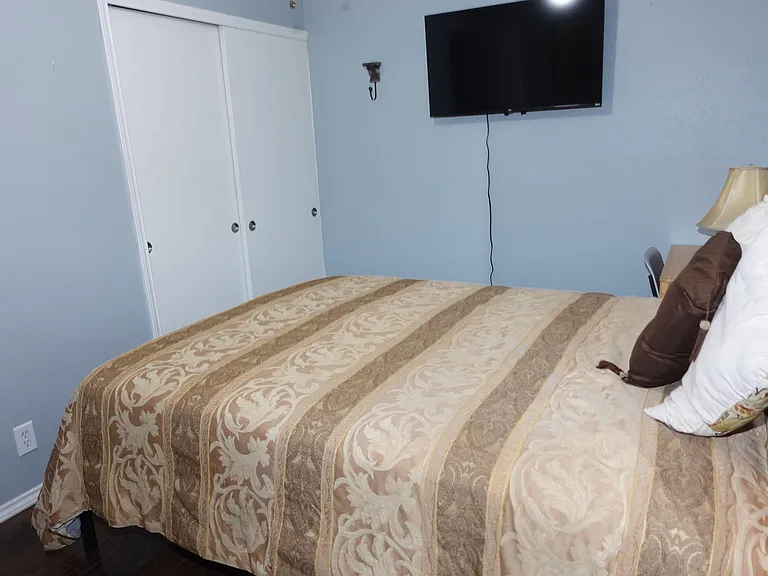 Furnished bedroom with a queen bed, sliding-door closet storage, and a wall-mounted 40 inch TV for convenient downtime.