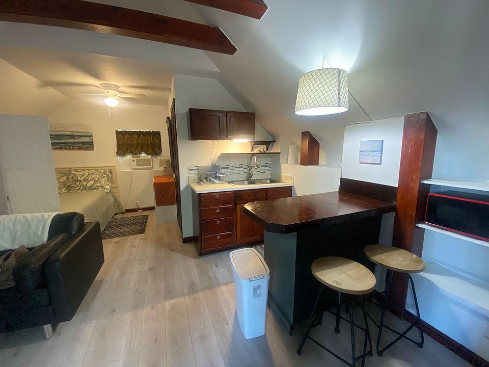 The unit has one large area divided into a kitchen w/bar, living room, and a bed separated by a movable room divider.