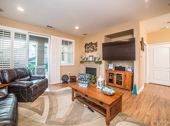 The living room has a gas fireplace and an enterta