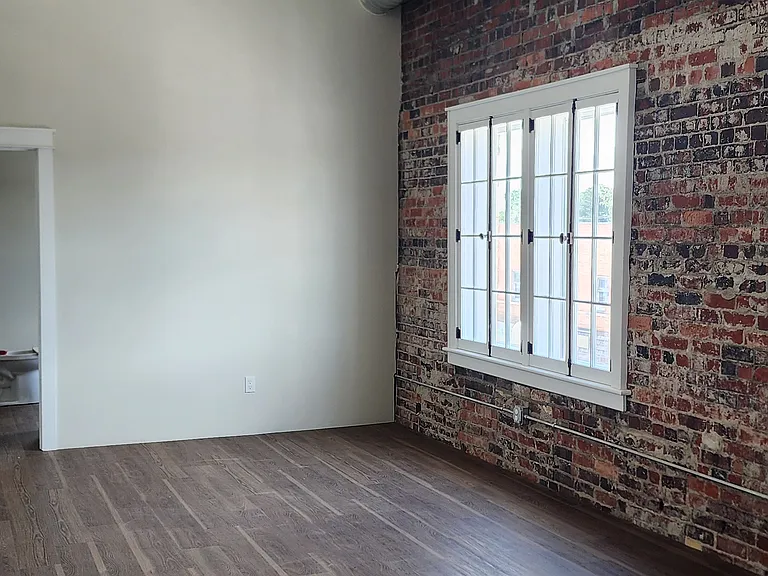 living room - beautiful exposed brick, high ceilings, and natural light
