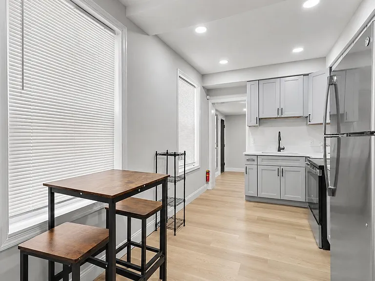Open kitchen with stainless appliances, generous cabinet storage, and an adjacent dining nook by large windows.