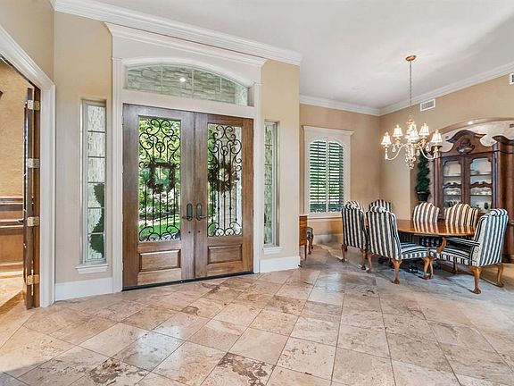 A place for dinner parties or special family meals-the dining room is accented with a striking travertine/mosaic inset,plantation shutters, and gorgeous lighting
