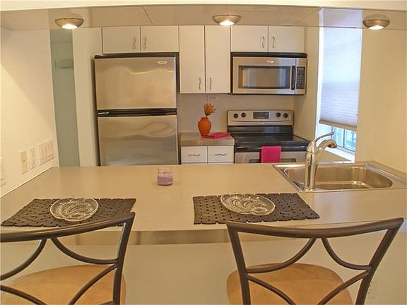 Dine at the bar. Note stainless appliances in kitchen
