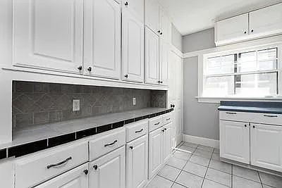 Tile work station with tile back splash. Tons of cabinet space. Entrance to basement also has side door to outside for easy moving. Basement has a lot of storage and 1/2 bath, furnace, hot water heater, work bench.
