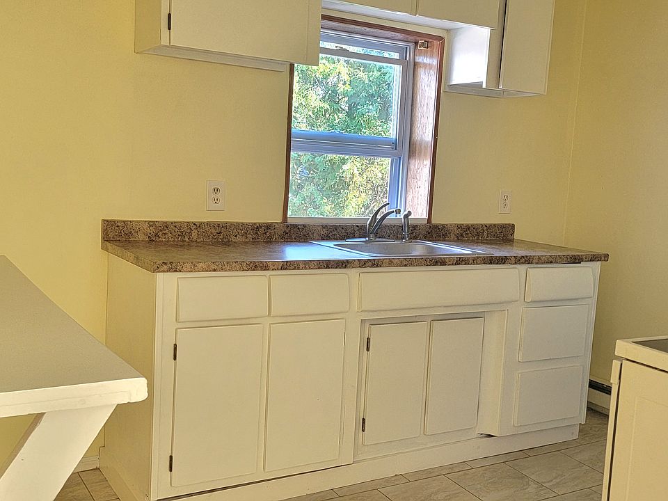 Kitchen has breakfast bar and new stainless refrigerator. Tiled flooring