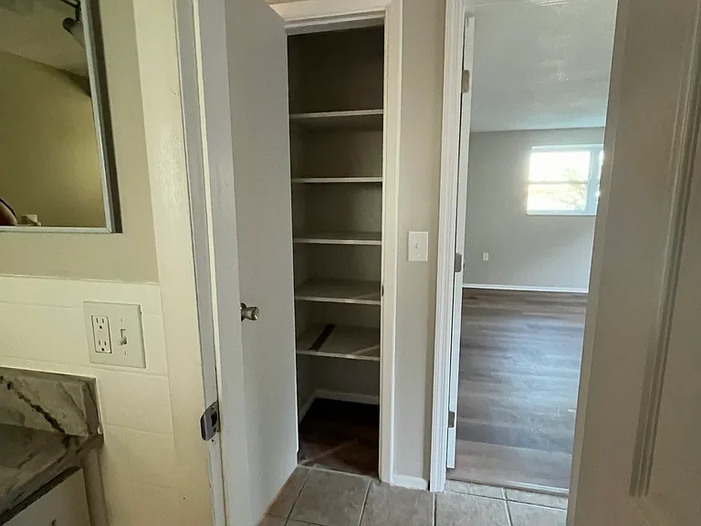Looking from the 2nd bathroom, which is shared by 2 bedrooms on the left side of the house, out into the hall/linen closet and front bedroom