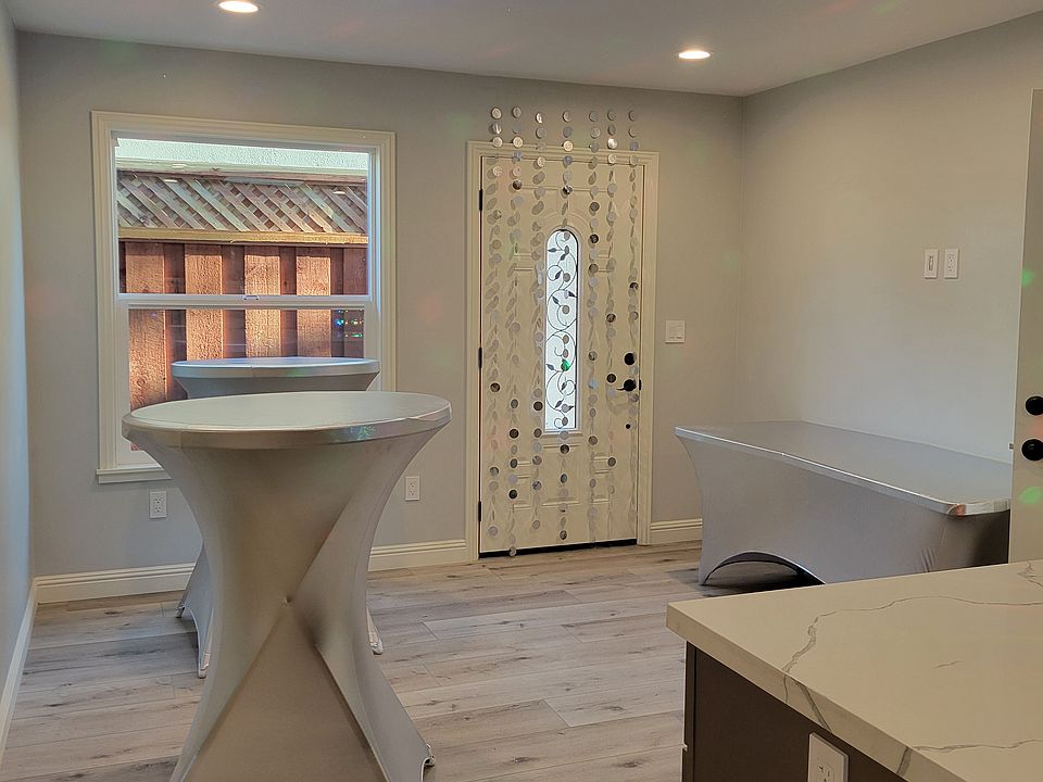 Large island divides the kitchen and living room area. Living room provides ample room for a couch and installation of large smart TV.