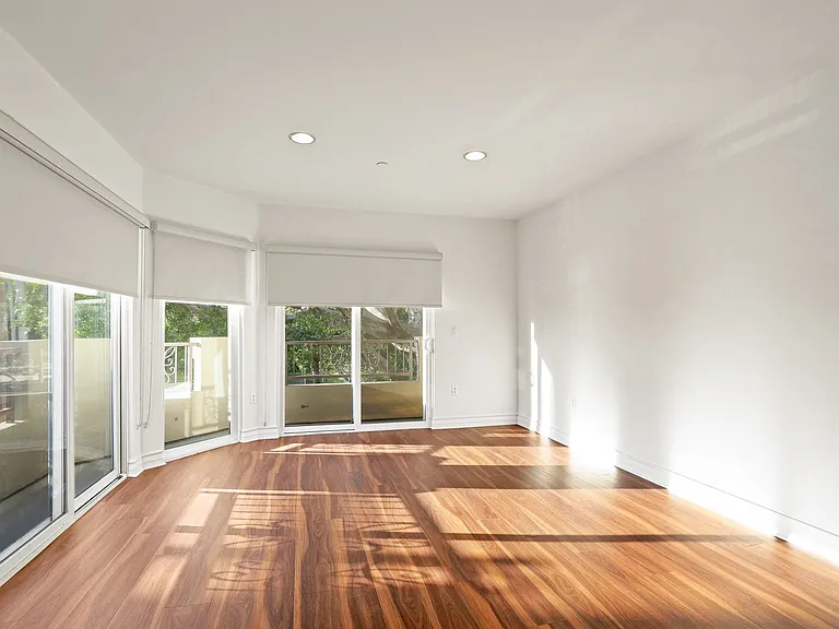 Large Bright Living Room Space with Balcony, Custom Shades, and Lots of Windows