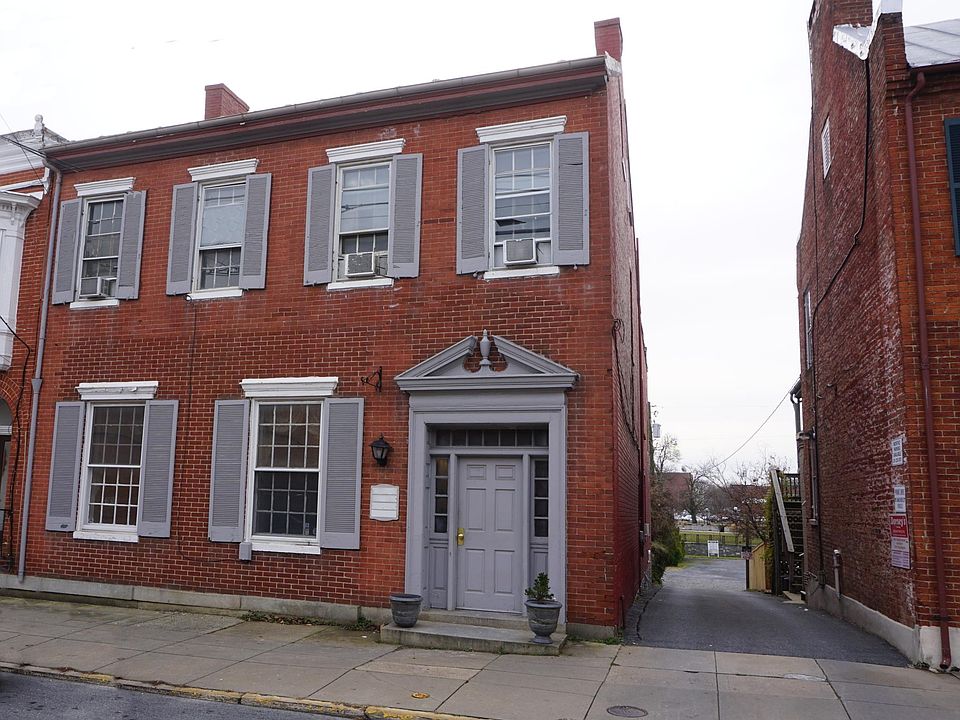 Front of building showing alley to parking area and garage behind building.