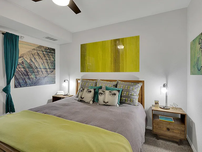 Cozy bedroom with chic decor, featuring contemporary art pieces, elegant bedside lamps, and stylish accent pillows, perfect for modern living.