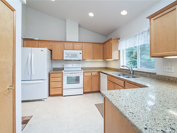 The kitchen features quartz counters, a dual stainless steel sink, and maple cabinets.