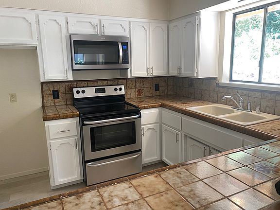full kitchen with induction stove top electric oven, medium white fridge, microwave fan combo and dishwasher