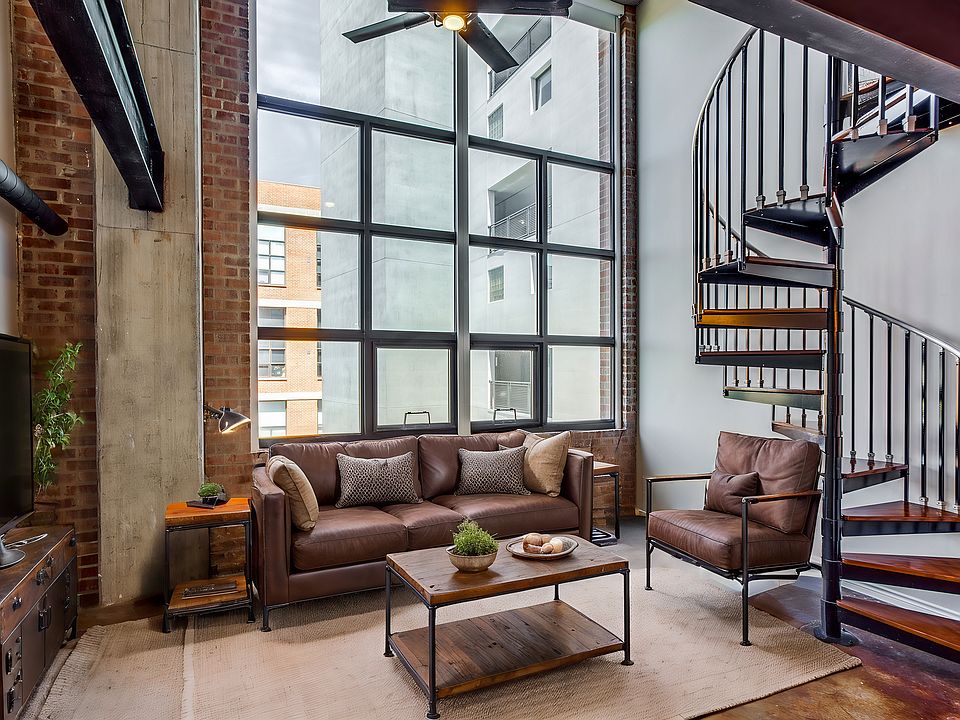 Ascend to your bedroom loft in style with a stunning spiral staircase that adds an architectural flair and a touch of sophistication to your living room space. (virtually staged)
