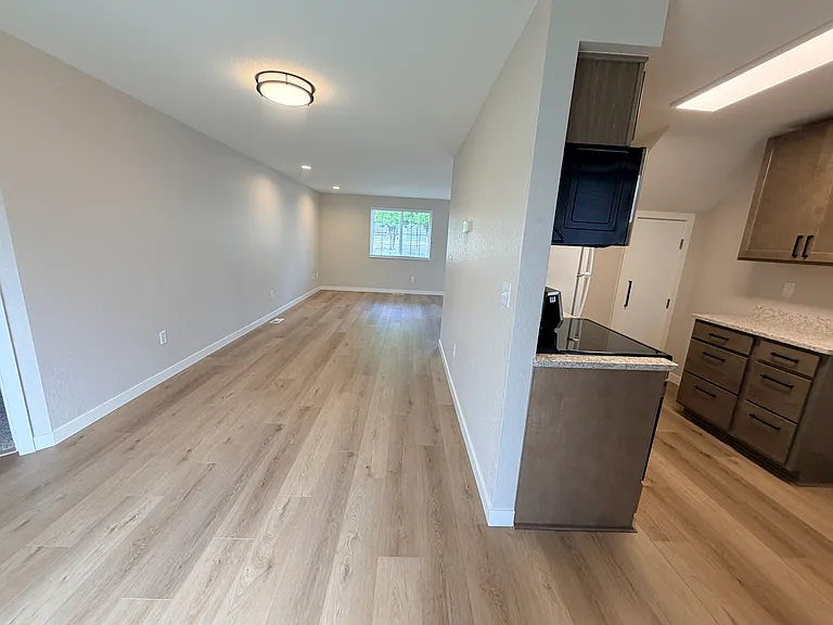 Kitchen on the right, eat-in area in the middle, and a peak of the primary bedroom on the left. (It's not really as elongated as this!)