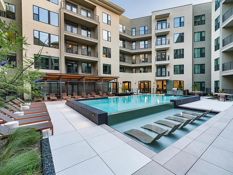 Relax in style at Modera Trailhead's resort-inspired pool, featuring in-water loungers and ample deck seating for sun-soaked days in Dallas.