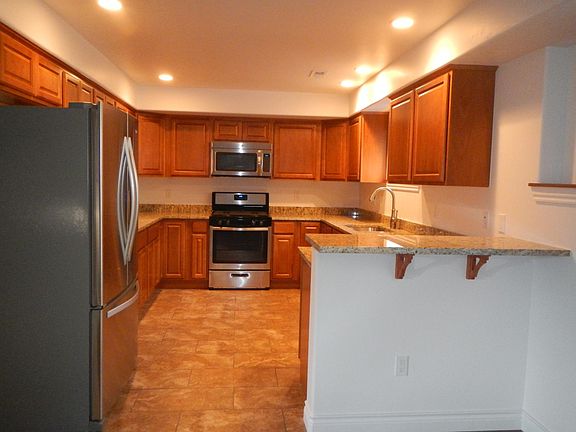 Kitchen with granite countertops, stainless appliances to include, refrigerator, gas stove, oven, microwave, dishwasher, disposal