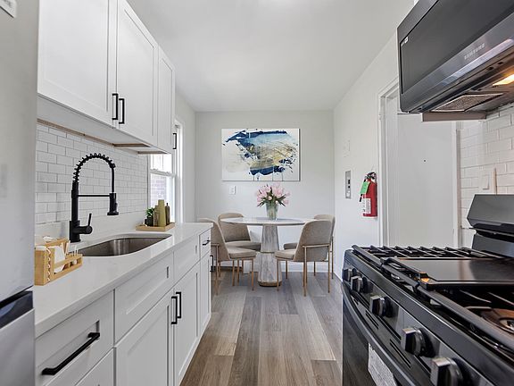 New kitchen with white shaker cabinets, subway tile backsplash, new applinaces and new floors. Furniture is virtually staged.