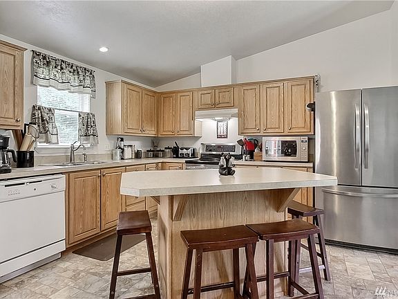 View of kitchen with included appliances, nice island! Cathedral ceilings throughout. 