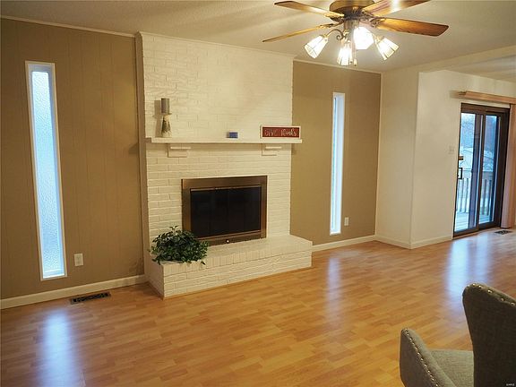 Family room, freshly painted, brick wood-burning fireplace, wood flooring