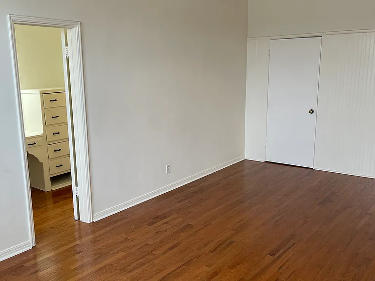 203 Main room looking into dressing/closet/bathroom wing of 3-wing suite. Closets along back wall. Ceiling fan.