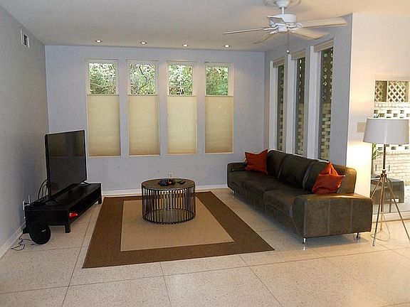 Den with Ceiling fan and a view of the patio.