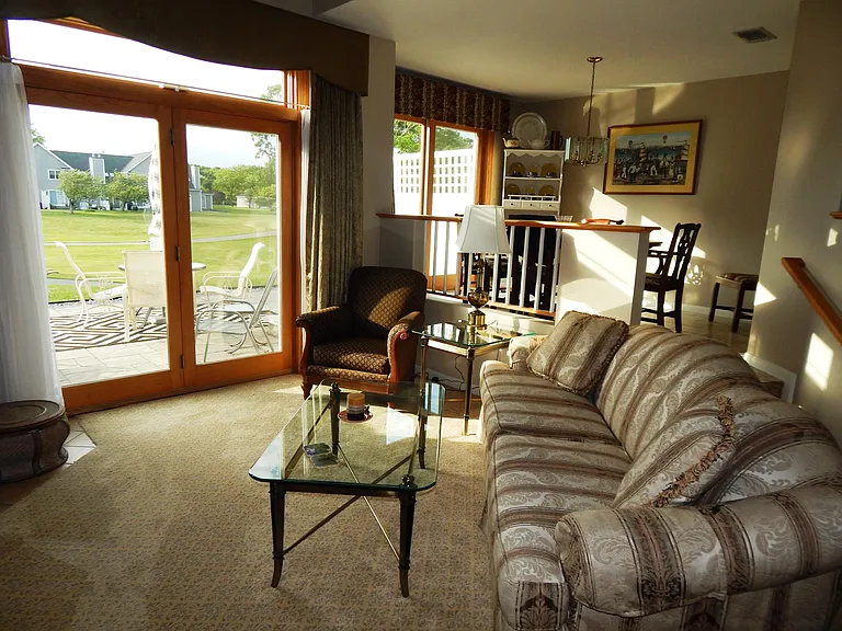 Formal living room, comfortable Thomasville sofa & chairs, glass-top brass coffee & end tables.