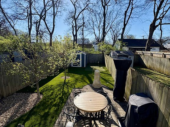 Fully fenced turf backyard with two hole putting green and patio.