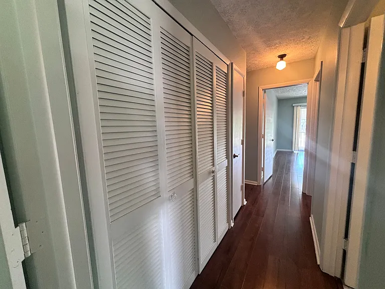 Hallway between both bedrooms, laundry closet on left, guest bath on right. Primary bedroom and bath is straight ahead.