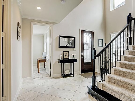 Entryway is 2 story and spacious. Downstairs guest room is located through the door straight ahead. Seller is using as an office. Full Bath located through the door on the left.