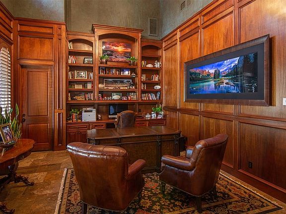 To the left of the entry is the formal study with solid mahogany walls, 20 foot ceiling and a built-in gun case. There is an exterior door for private access. There is also a second functional office by the kitchen.