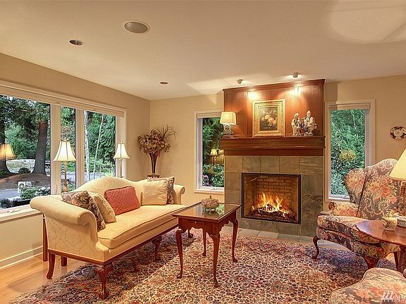 The formal rooms, with quarter sawn white oak floors, are adorned with custom furniture quality cherry built-ins with powder coated steel accents (which repeats throughout the home), the living room with a slate surround gas fireplace with custom mantel and sconces lighting. 