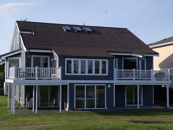 Back of the house showing both upper decks and lower patios with four walk out doors.