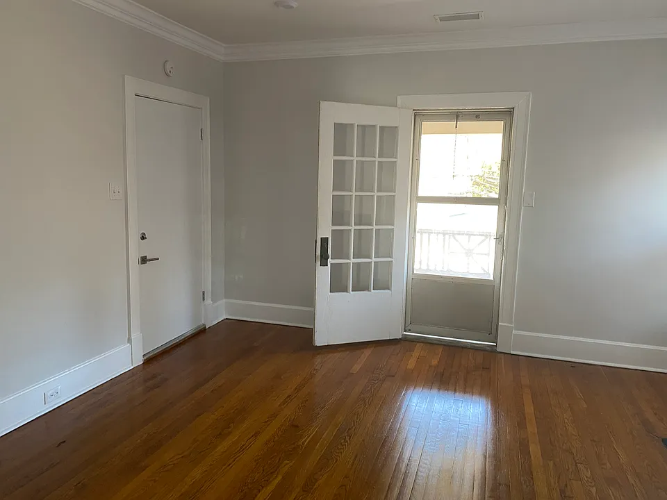 The living room. (Some people have used this as the bedroom & it's works really well like that!) 
The closed door is the internal stairwell. The glass door opens to your balcony.