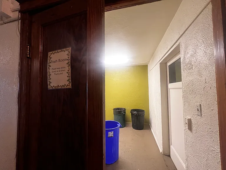 Trash room behind elevator.
