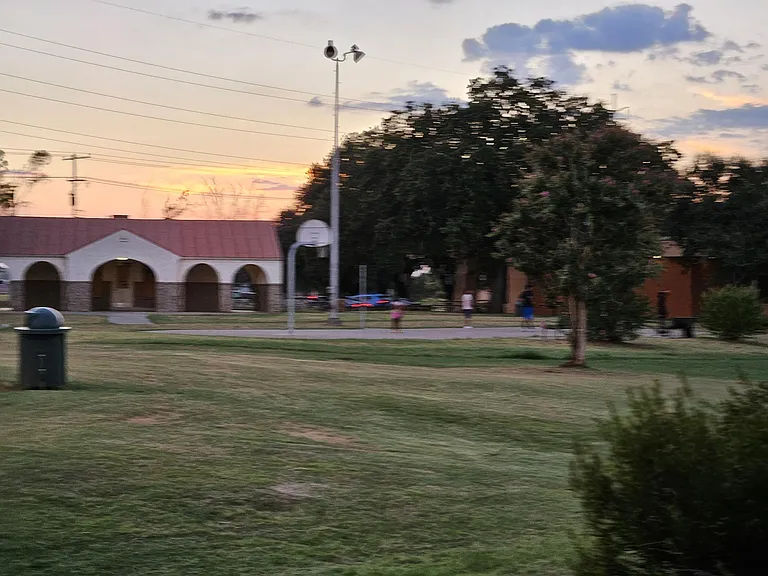 Grauwyler Park is just a few doors away. It hosts a Recreation Center, Library, multiple playing fields, paved walking path, playground, pool, and a splashpad/sprayground. this photo shows the outdoor basket ball courts and Rec Center.