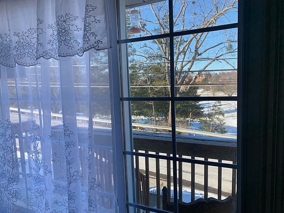 This is the comfortable, Front Balcony Patio, with commanding views. The living room window, has sliding glass panels. The front door is located between the living room, and the patio and front lawn.