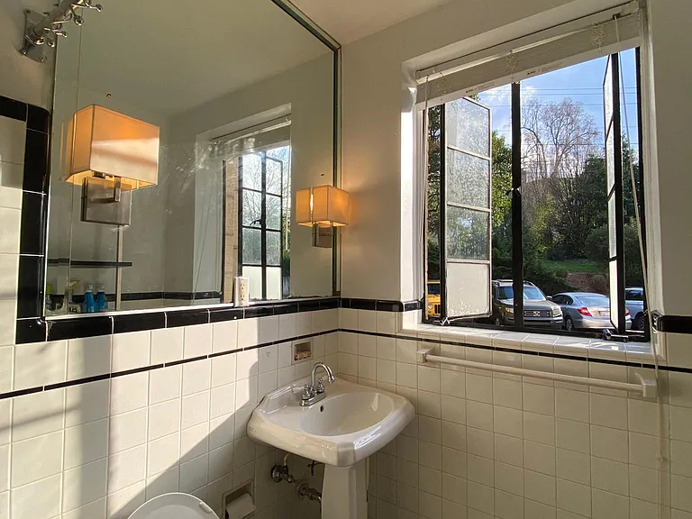 sunlit bathroom with custom tiling and enormous mirror! (windows open in this shot)