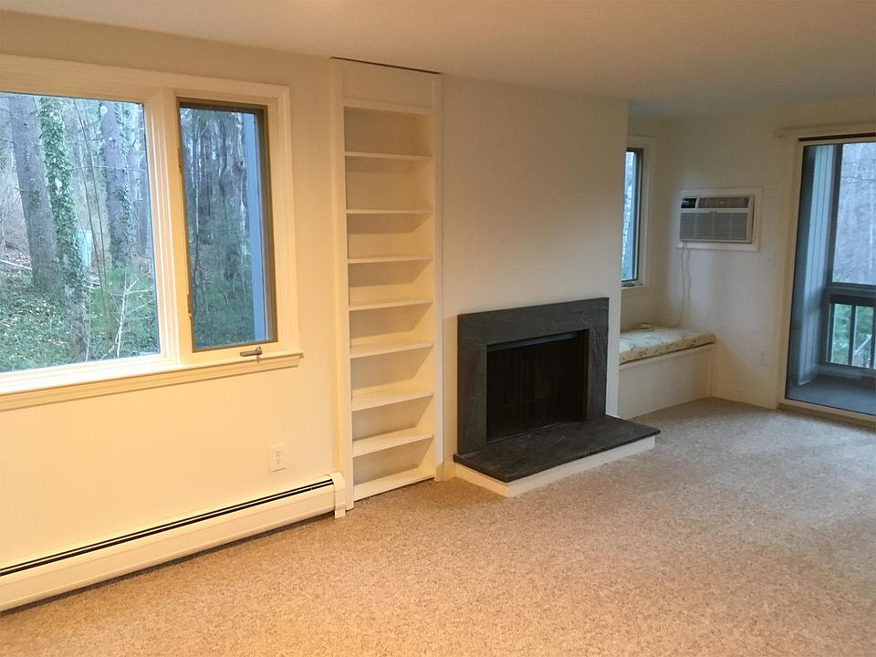 Living room with wood burning fireplace, window seat, built in bookcase.
